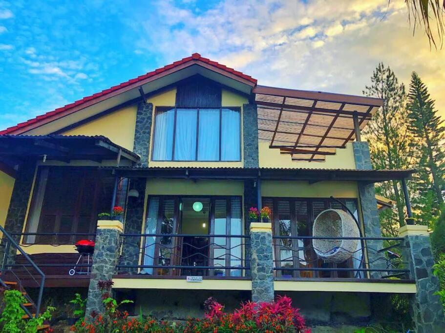 ein Haus mit einem Balkon und einem Himmel in der Unterkunft De Marlin's Garden Villa by GroRental in Tegalharendong