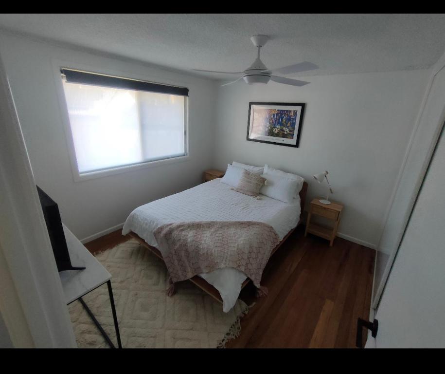a small bedroom with a bed and a window at Avondale Apartment in Lismore