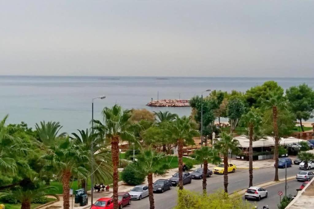 - un parking avec des voitures garées à côté de l'océan dans l'établissement Loveliest Place At AthensRiviera, à Vari