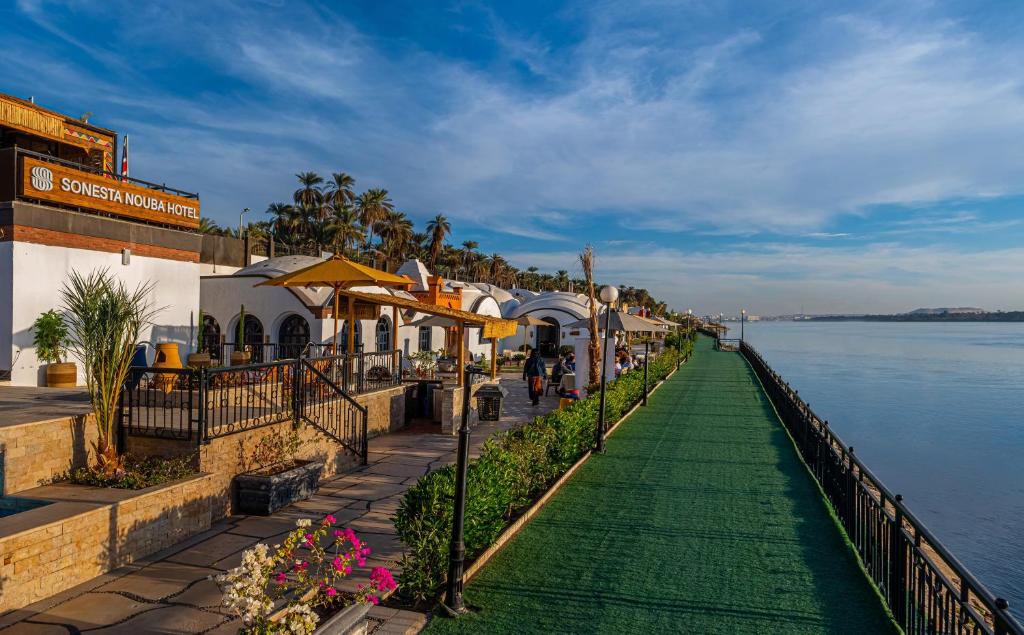 una pasarela junto a un cuerpo de agua en Sonesta Nouba Hotel Aswan, en Asuán