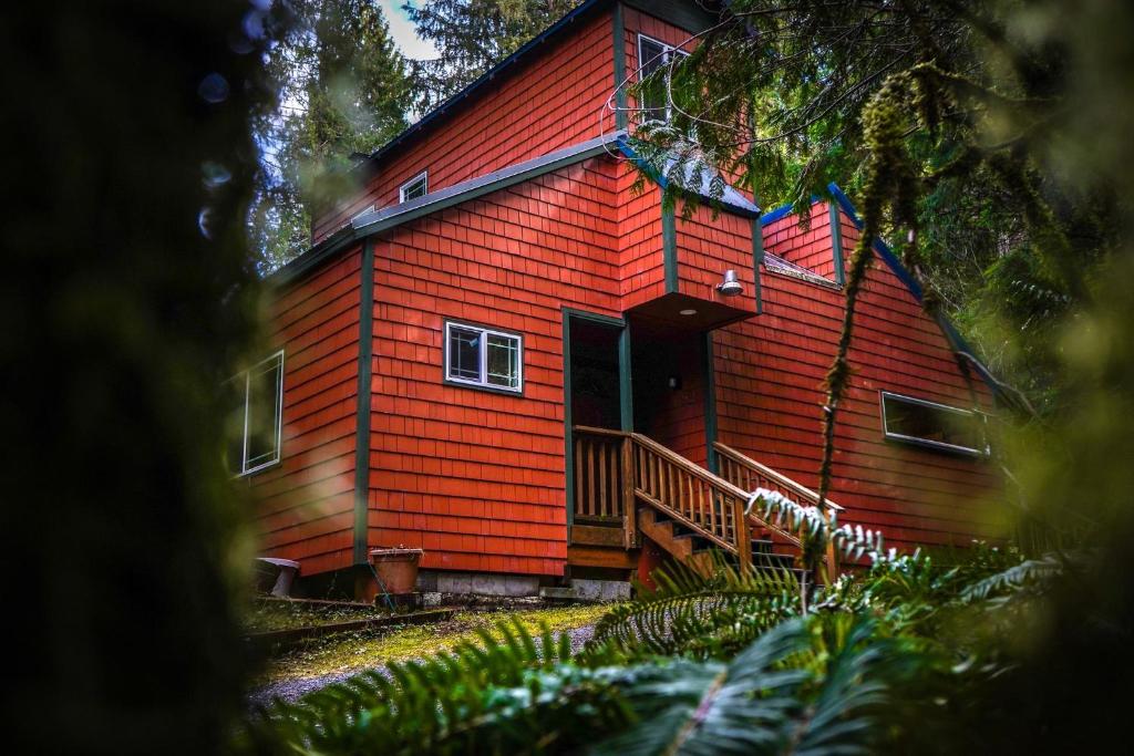 una casa roja con techo rojo y porche en Little Haven Cottage, en Glacier