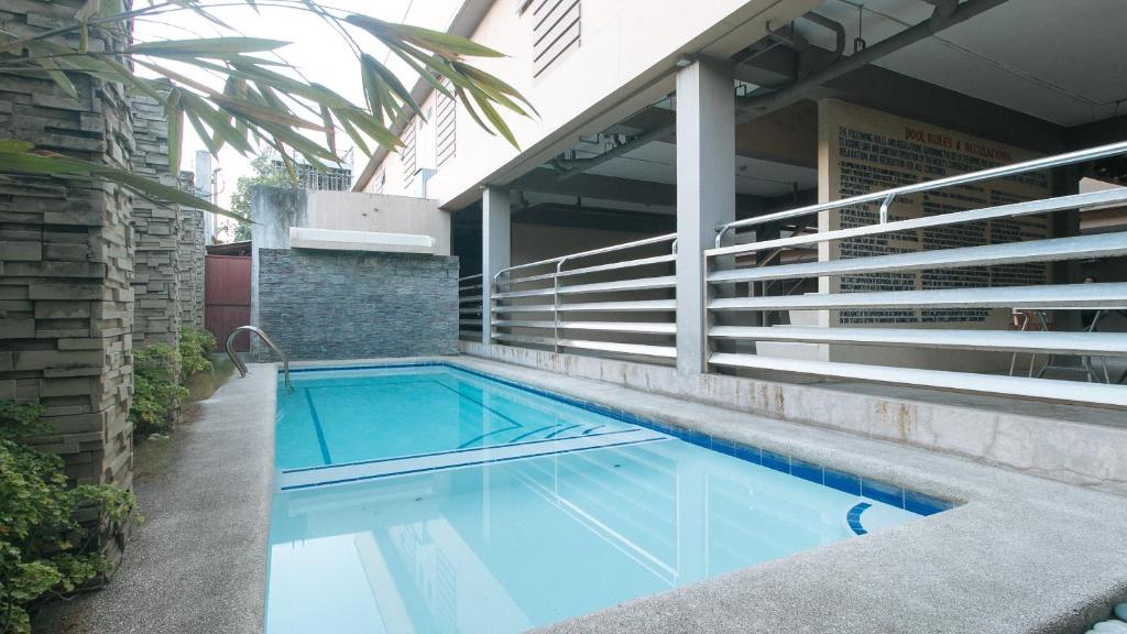 una piscina sul lato di un edificio di RedDoorz at Grand Apartelle Hernan Cortes Cebu a Cebu City