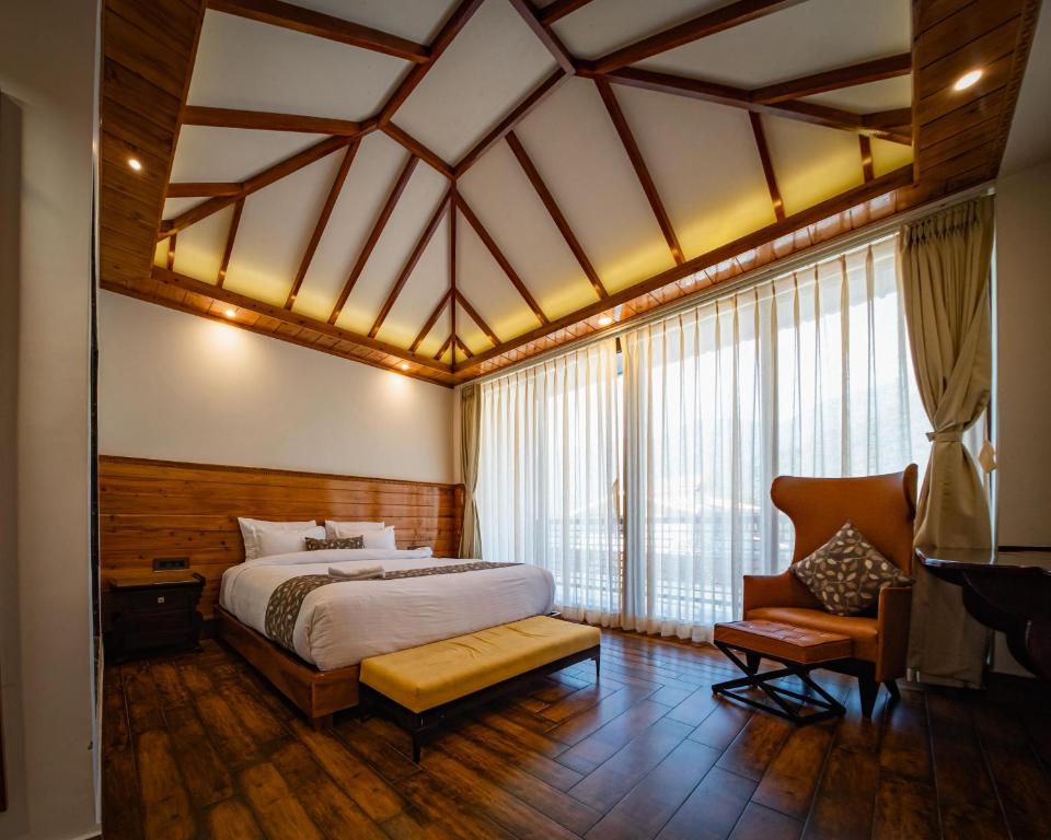 a bedroom with a bed and a chair at Namdul Retreat in Phensāng