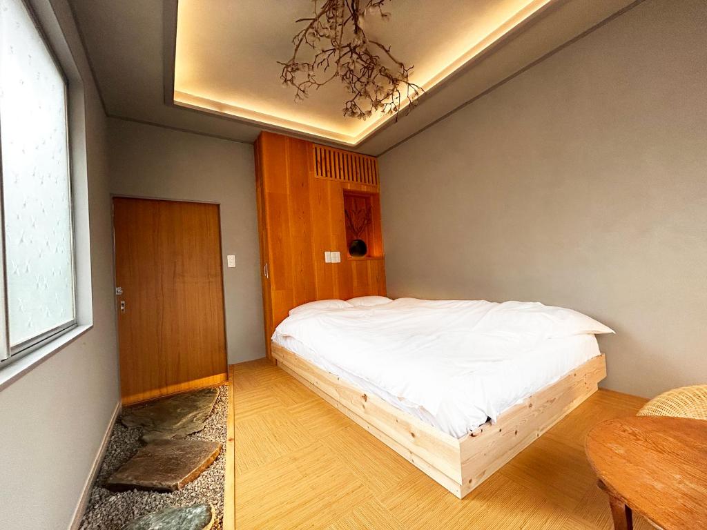 sypialnia z łóżkiem w rogu pokoju w obiekcie 満竹華庵 manchikan w Tokio