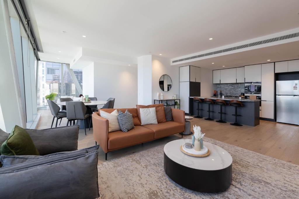 uma sala de estar com um sofá e uma mesa em Supreme Sub-Penthouse - 3 Bedroom 2 Bathroom Melbourne CBD em Melbourne