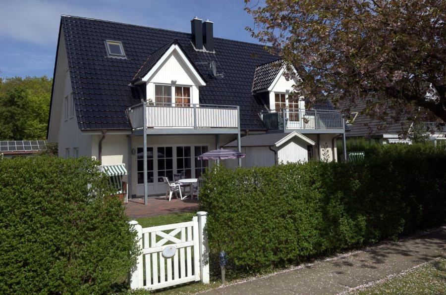 ein Haus mit einem weißen Zaun davor in der Unterkunft Bi de Park in Wyk auf Föhr