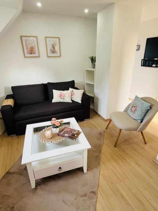 ein Wohnzimmer mit einem schwarzen Sofa und einem Couchtisch in der Unterkunft Mia’sFerienwohnung/Monteurwohnung in Herborn