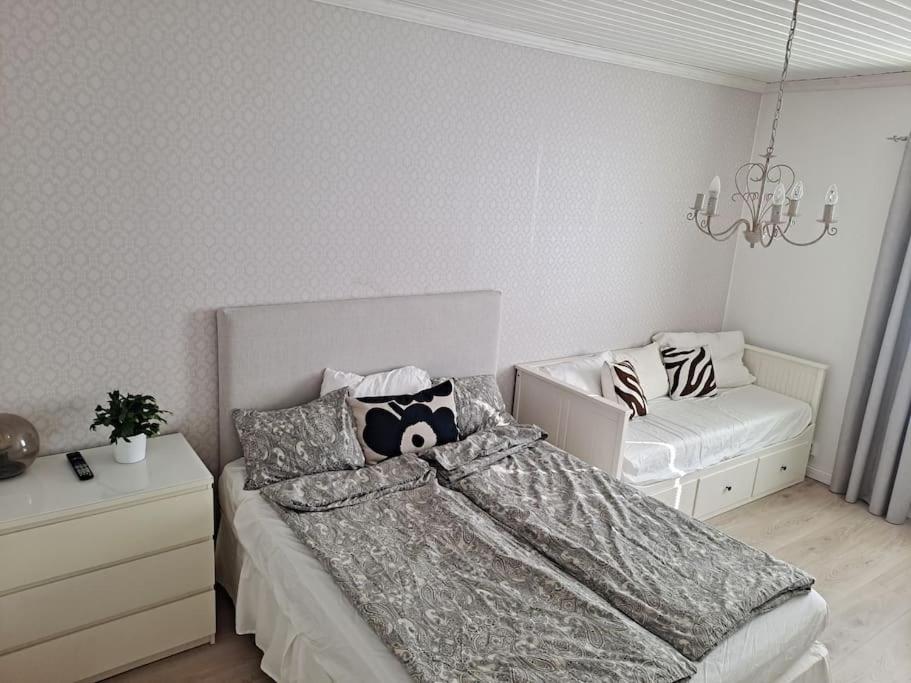 a bedroom with a bed and a chandelier at Spacious apartment in the city center in Vaasa