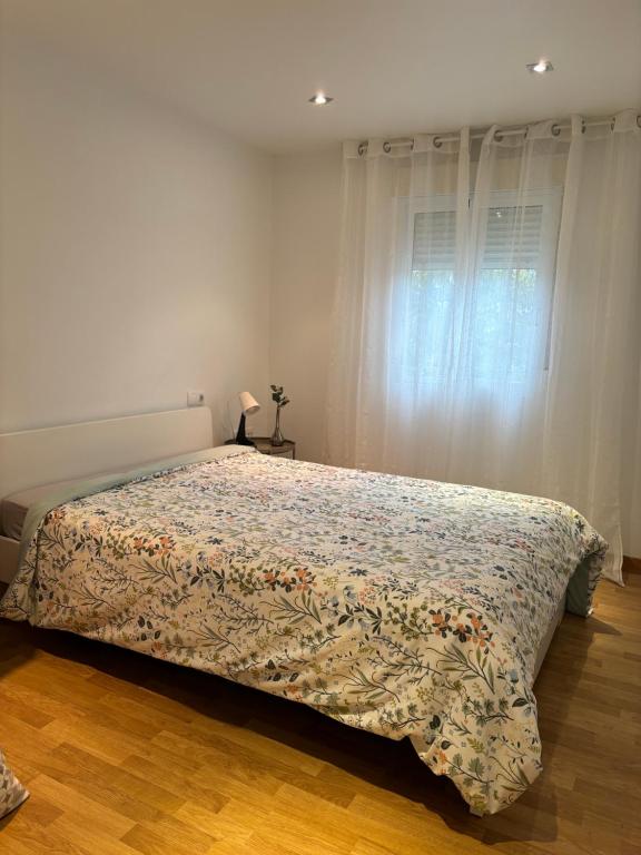 Un dormitorio con una cama con una colcha floral. en Apartamento Patty, en Elche