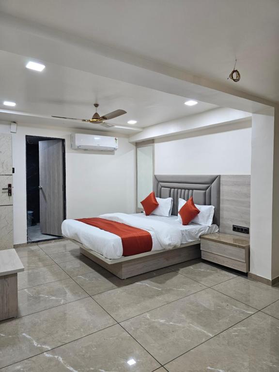 een slaapkamer met een groot bed met rode kussens bij HOTEL R K VILLA in Ahmedabad