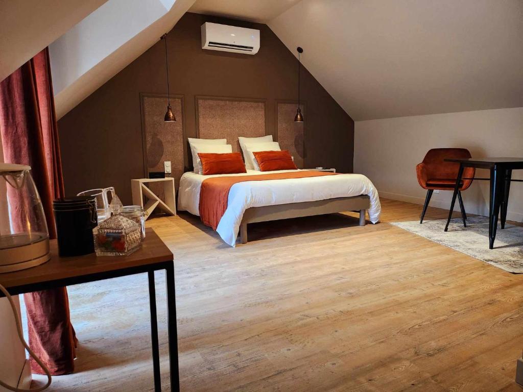 een slaapkamer met een bed met oranje en witte kussens bij Ti Ar Kalon, maison proche de Quimper in Landudal