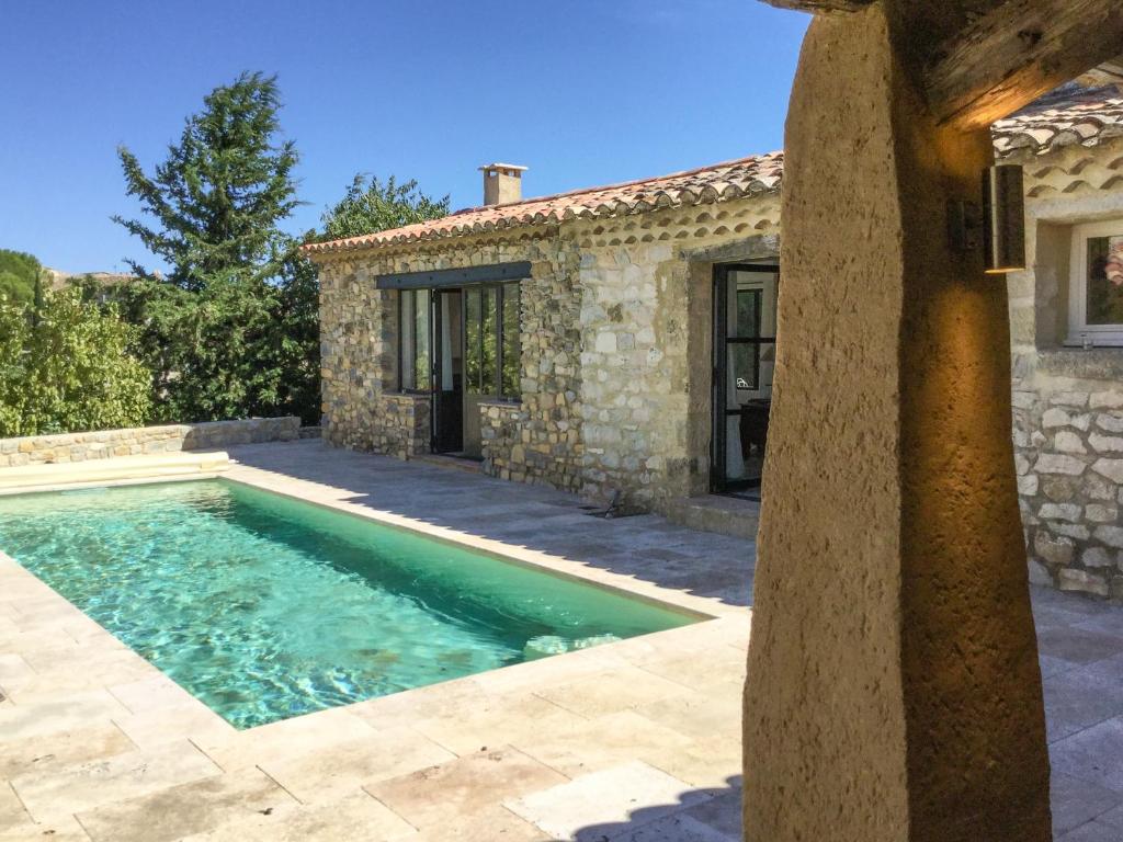 - une piscine en face d'une maison en pierre dans l'établissement Le Petit Mas, à Belvézet