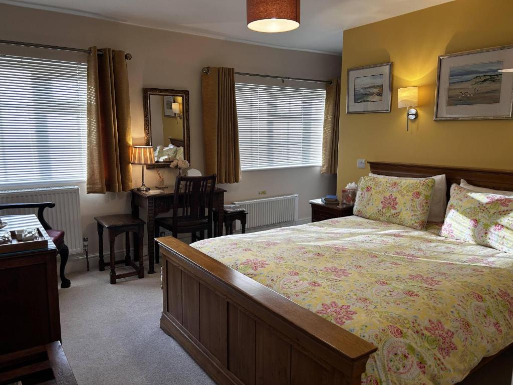 a bedroom with a bed and a table and a desk at The Old Posthouse B&B in Caenby