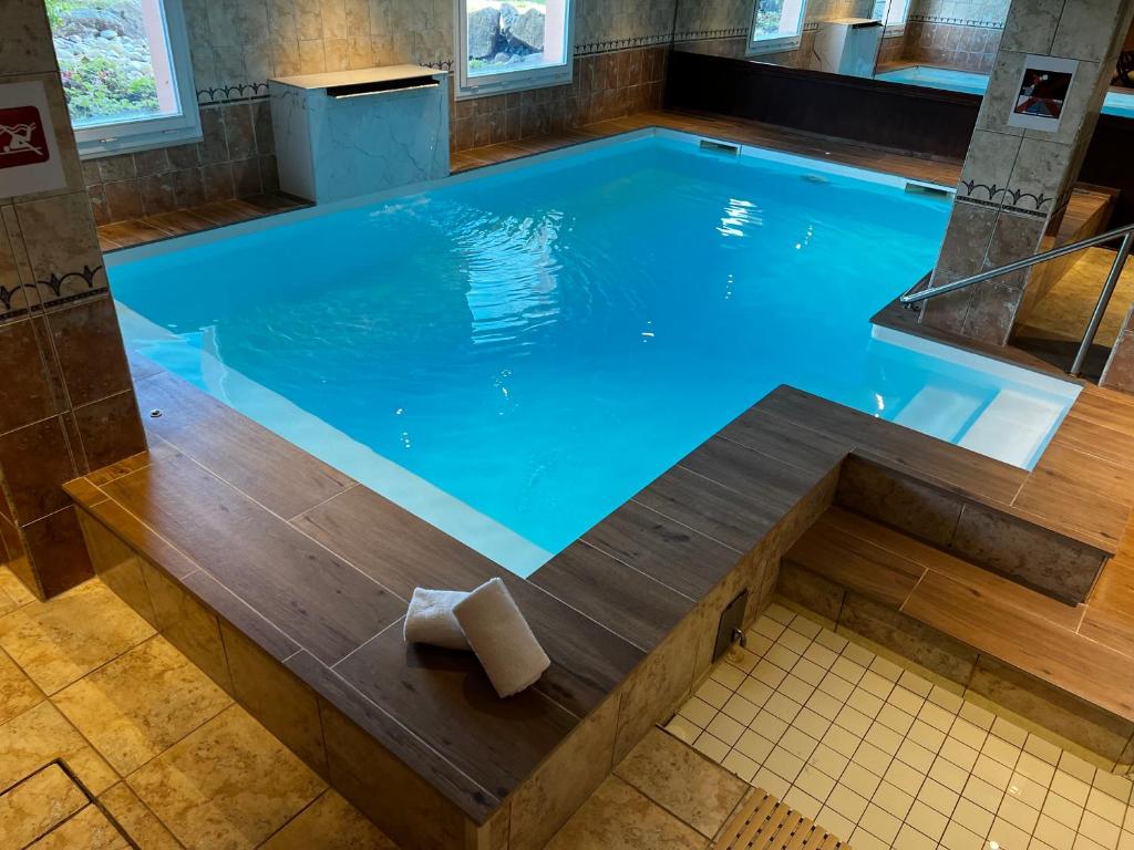 una gran piscina alargada con un banco de madera alrededor en Hôtel Le Riquewihr, en Riquewihr