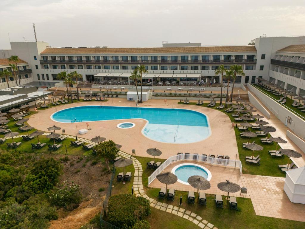 an overhead view of a resort pool with chairs and umbrellas at Ilunion Calas de Conil in Conil de la Frontera