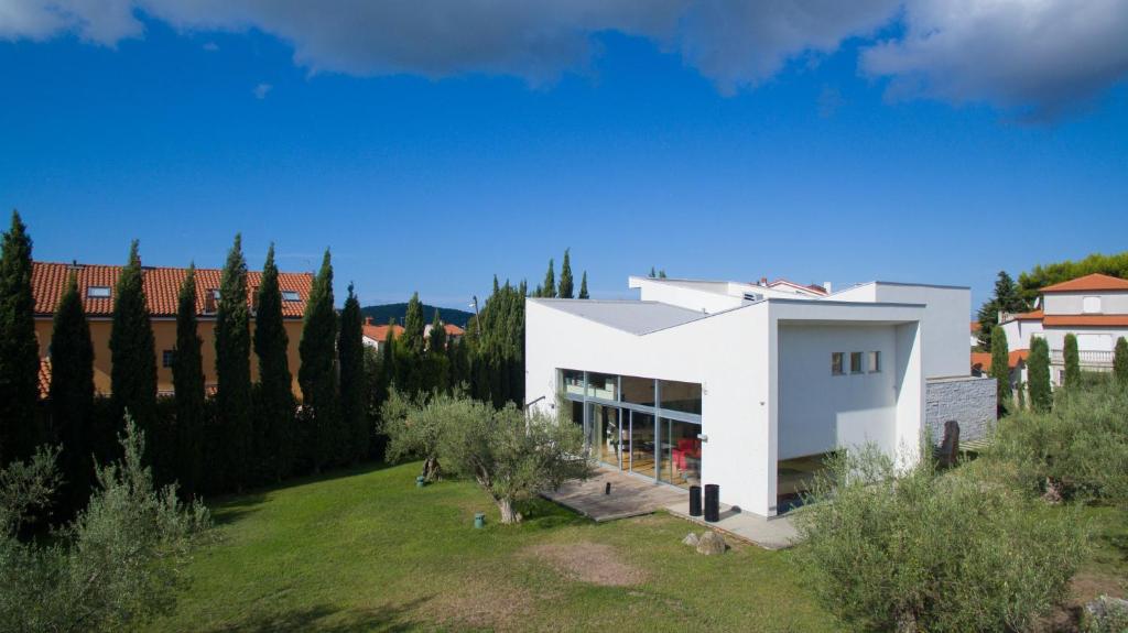 a white house on a hill with trees at Studio OM by Valsabbion in Medulin