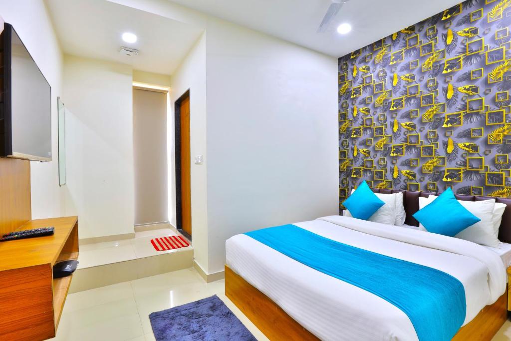 - une chambre avec un grand lit et une télévision dans l'établissement Hotel Shivaay, à Ahmedabad