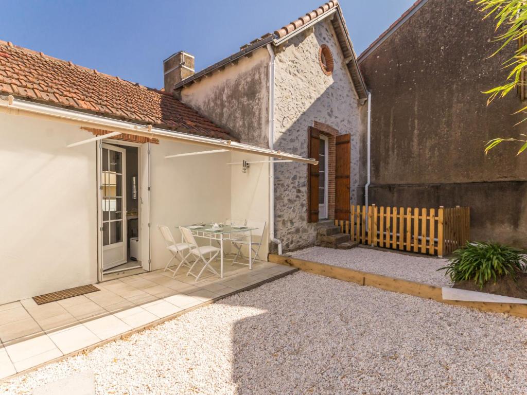 a patio with a table and chairs next to a building at Maison familiale moderne, 300m du centre, 500m de la mer, WIFI gratuit, draps inclus. - FR-1-306-1206 in Saint-Brevin-les-Pins