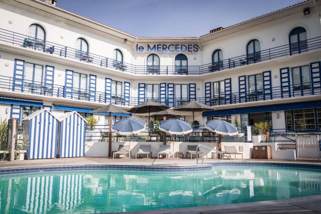 a hotel with a swimming pool in front of a building at Hotel Mercedes in Hossegor