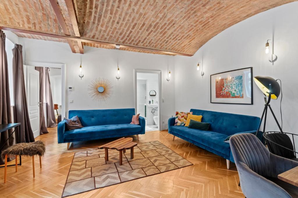 ウィーンにあるFarawayHomes Studio Vienna #B2の青いソファと木製の天井が備わるリビングルーム