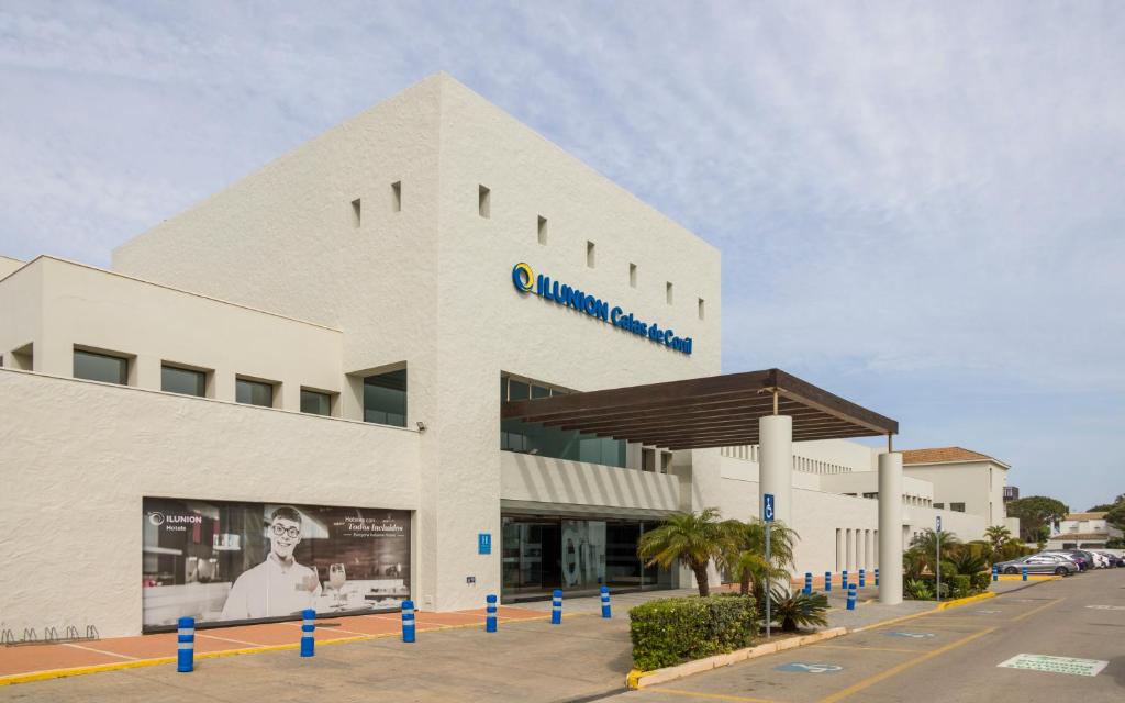a large white building with a sign on it at Ilunion Calas de Conil in Conil de la Frontera