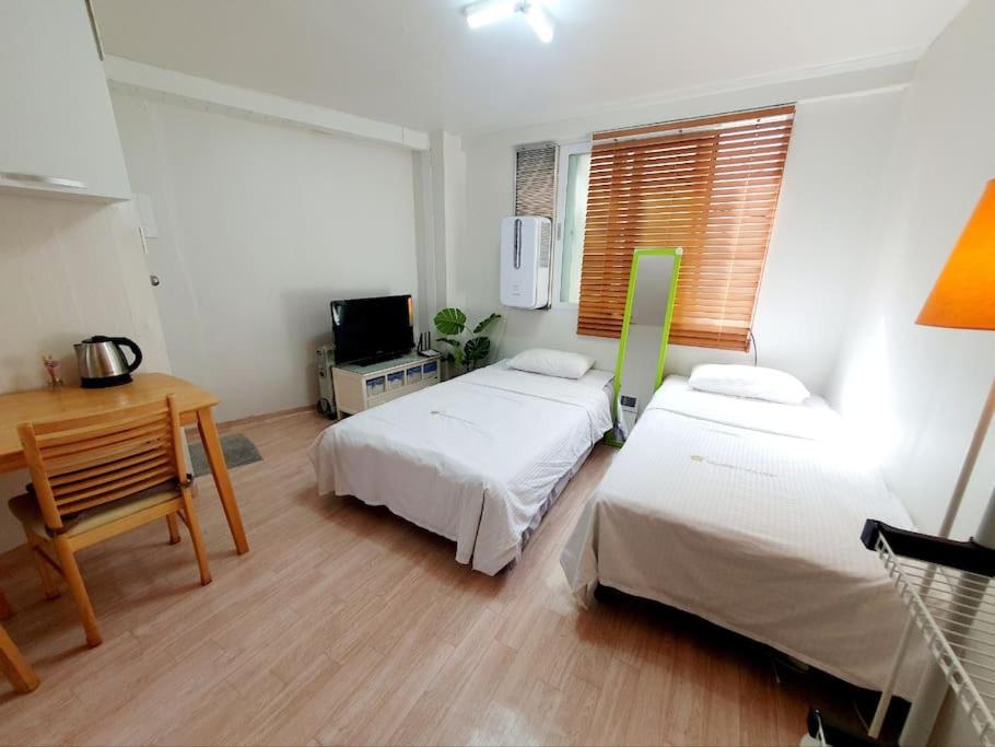 a bedroom with two beds and a desk and a window at Mong House #Mangwon-dong Mangridangil 2F Private stay in Seoul