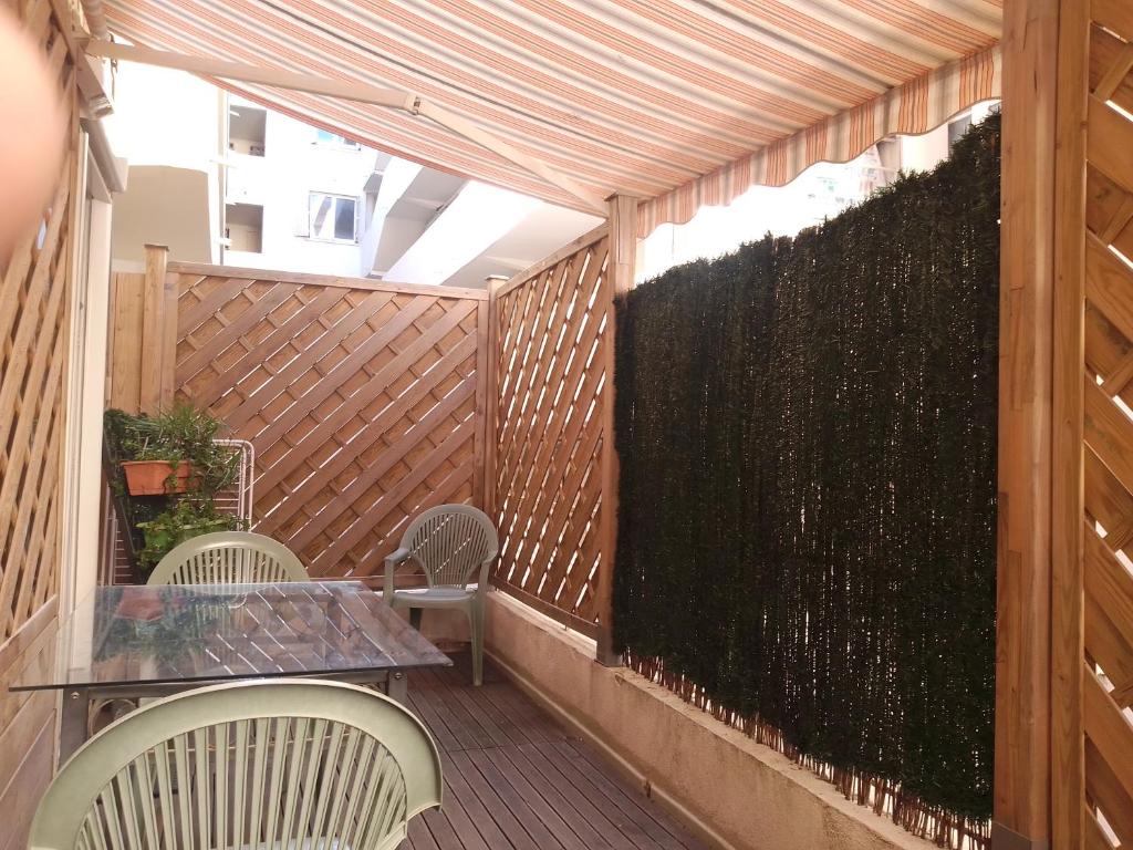 d'une terrasse avec une table, des chaises et une clôture. dans l'établissement studio terrasse, à Toulon
