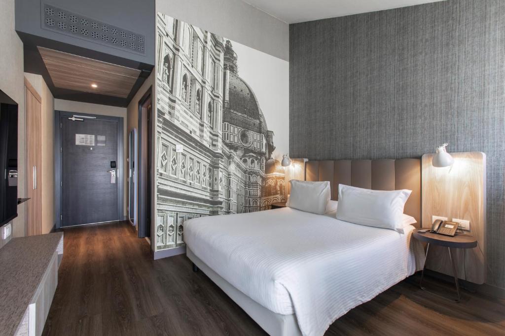 フィレンツェにあるメルキュール フィレンツェ セントロの白い大型ベッドと壁画が備わるベッドルーム1室が備わります。