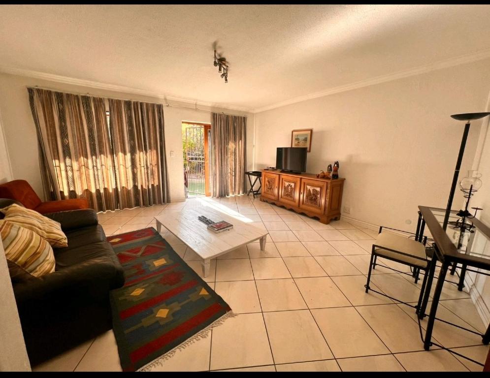 uma sala de estar com um sofá e uma mesa em OakTree Guest House em Sandton