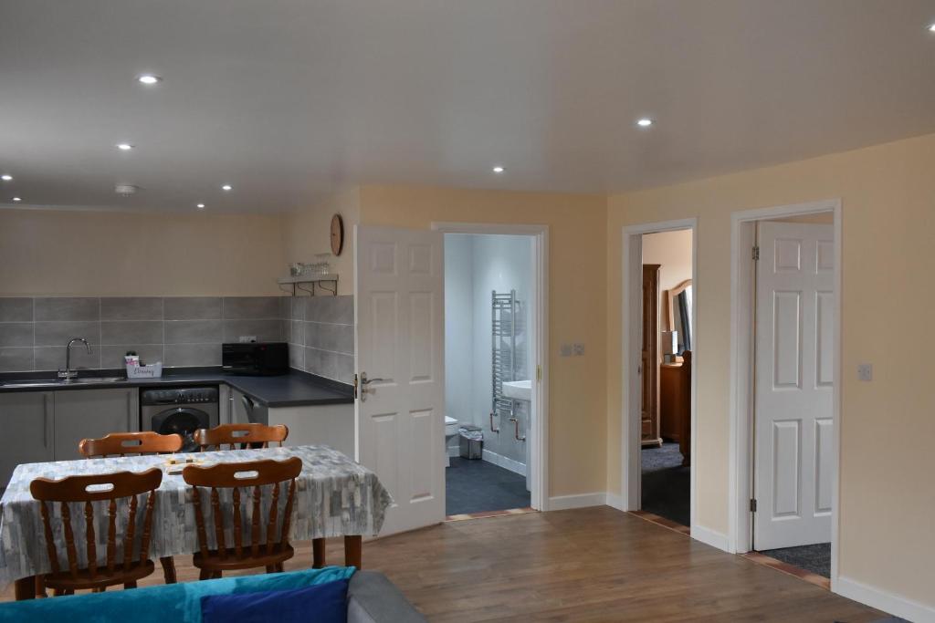 a kitchen and dining room with a table and chairs at 4 Woodyard Cottages, 2 Bedroom with free parking. in Long Sutton