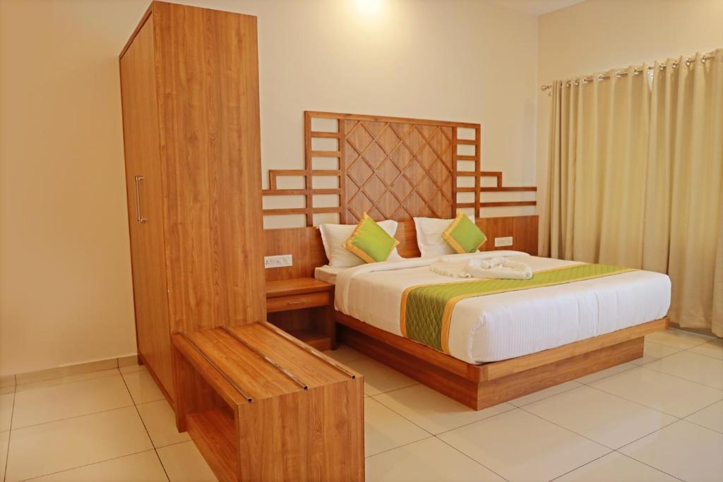 sypialnia z łóżkiem z drewnianym zagłówkiem w obiekcie MISTY DALE MUNNAR RESORT & SPA w mieście Anachal