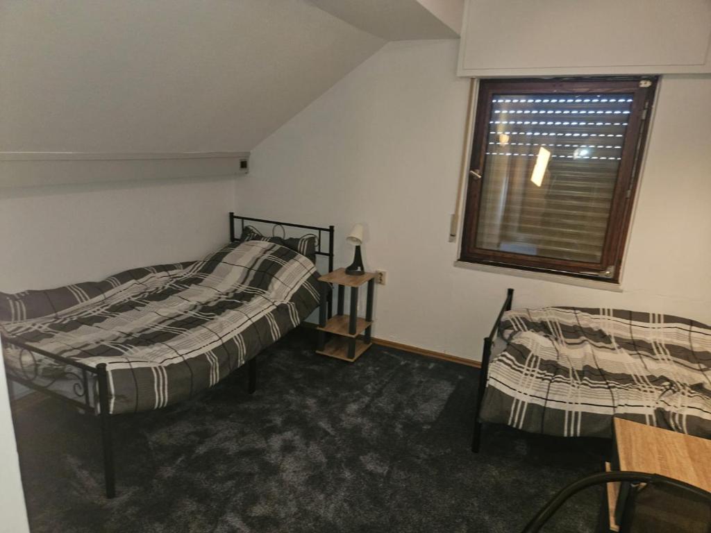 una camera con due letti e una finestra con una tenda di Monteurzimmer WG Zimmer Kurzzeitmieter *in a Düren - Eifel