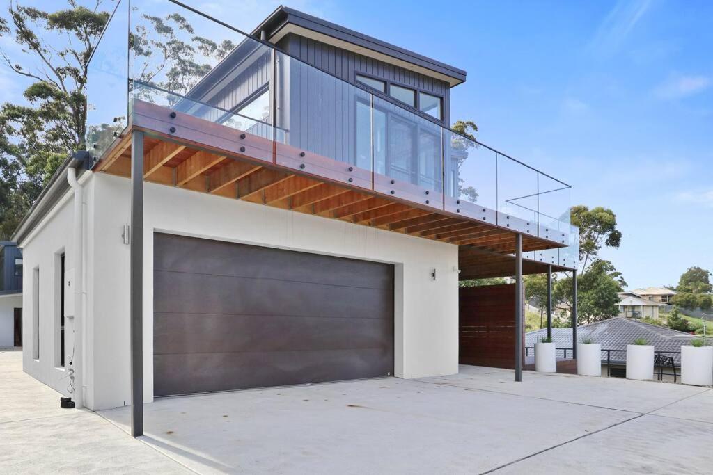 una casa con porta-garage e balcone di The Lake House & Apartment a Merimbula