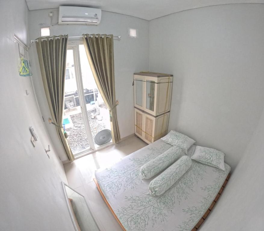 a small bedroom with a bed and a window at GKR J8 Homestay Jogja in Pedes