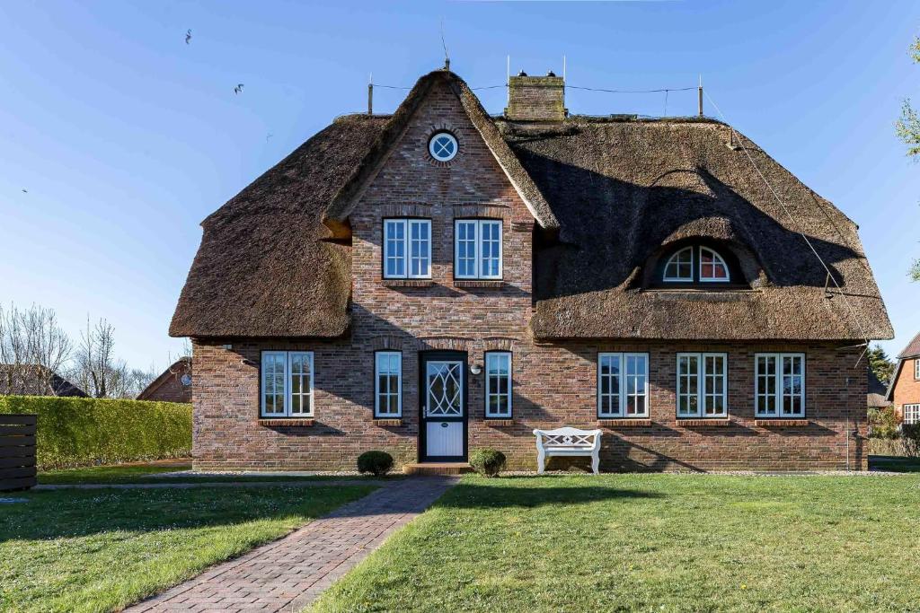 an old stone house with a thatched roof at Haus Marie in Utersum