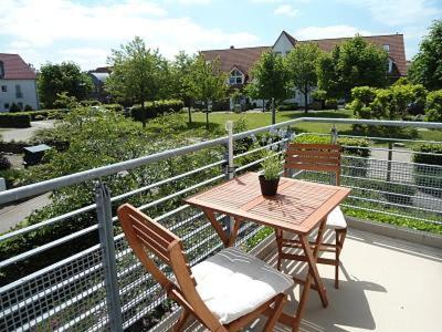 een houten tafel en stoelen op een balkon bij Kon 375 in Scharbeutz