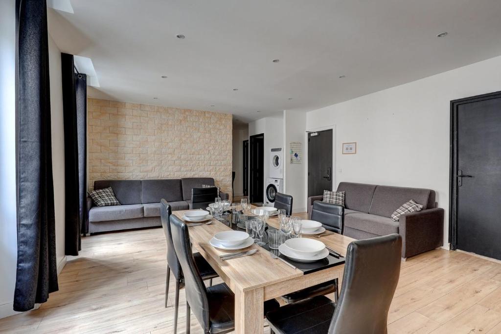 a dining room with a table and a couch at 126 Suite Abraham - Superbe Appartement à Paris in Paris