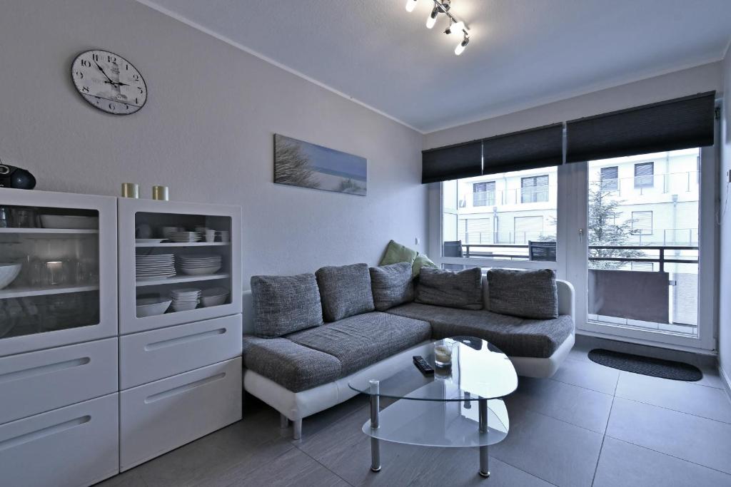 sala de estar con sofá y reloj en la pared en RES 408 - Residenz - Teilseeblick en Scharbeutz