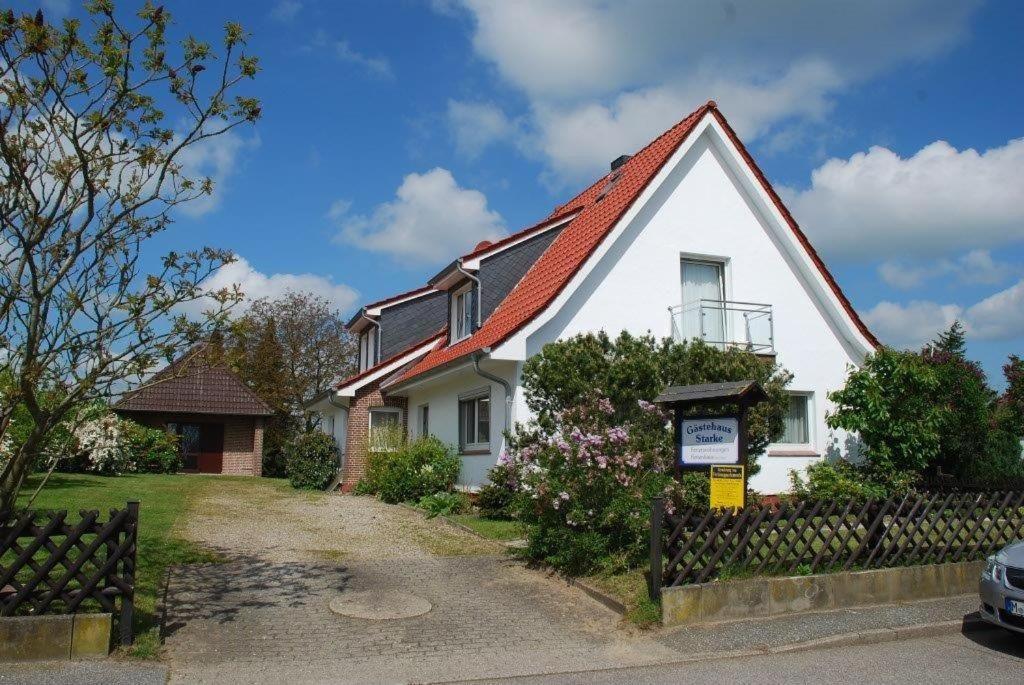 una casa bianca con tetto rosso di HAF OGL - Gästehaus Starke a Haffkrug