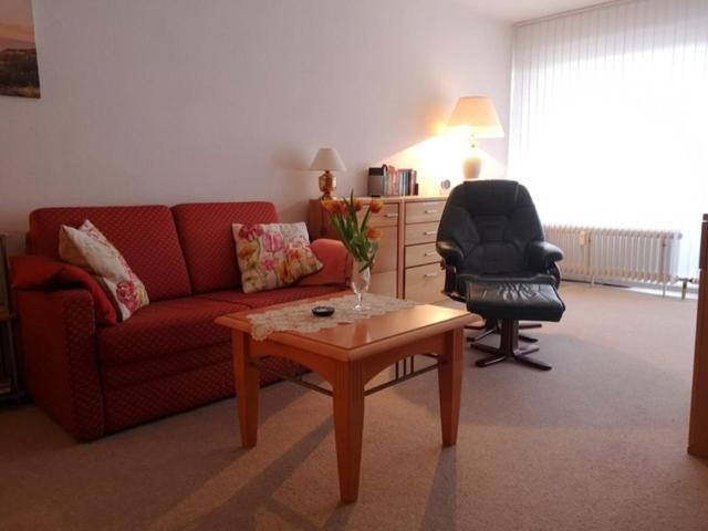 a living room with a red couch and a chair at RES 114 - Residenz in Scharbeutz