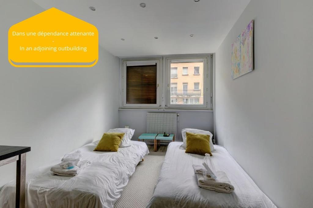 two beds in a room with a yellow sign at 235 Home Madrid Concept in Paris
