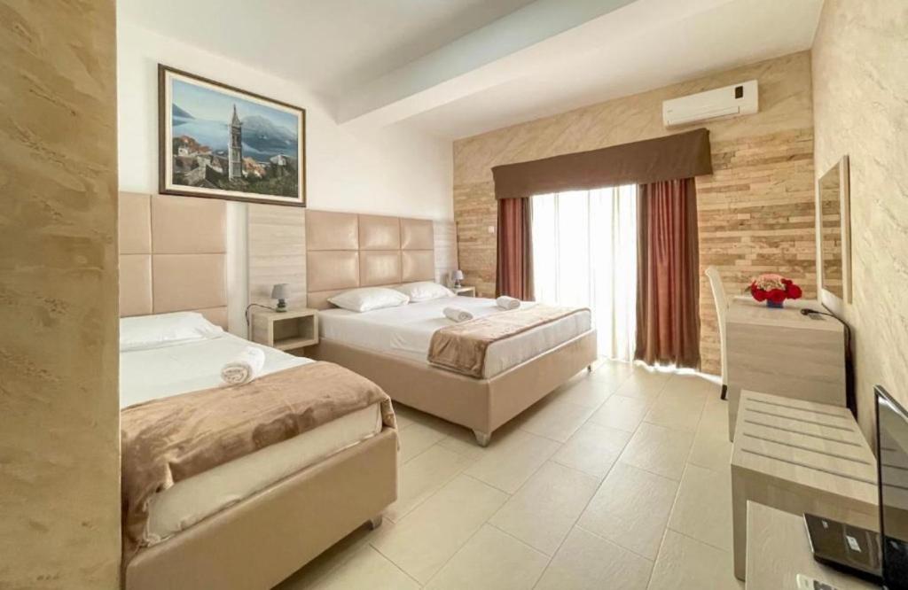 een hotelkamer met 2 bedden en een raam bij Imperial Hotel in Ulcinj