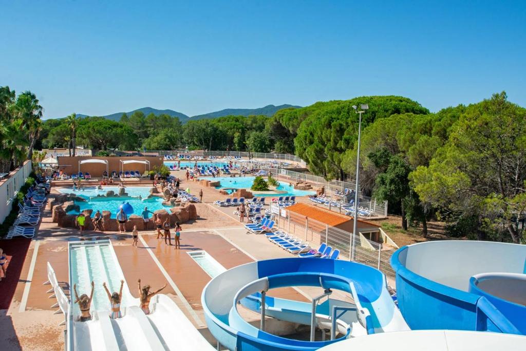 - une grande piscine avec des personnes séjournant dans un complexe dans l'établissement Mobil-home Camping Oasis, à Roquebrune-sur Argens