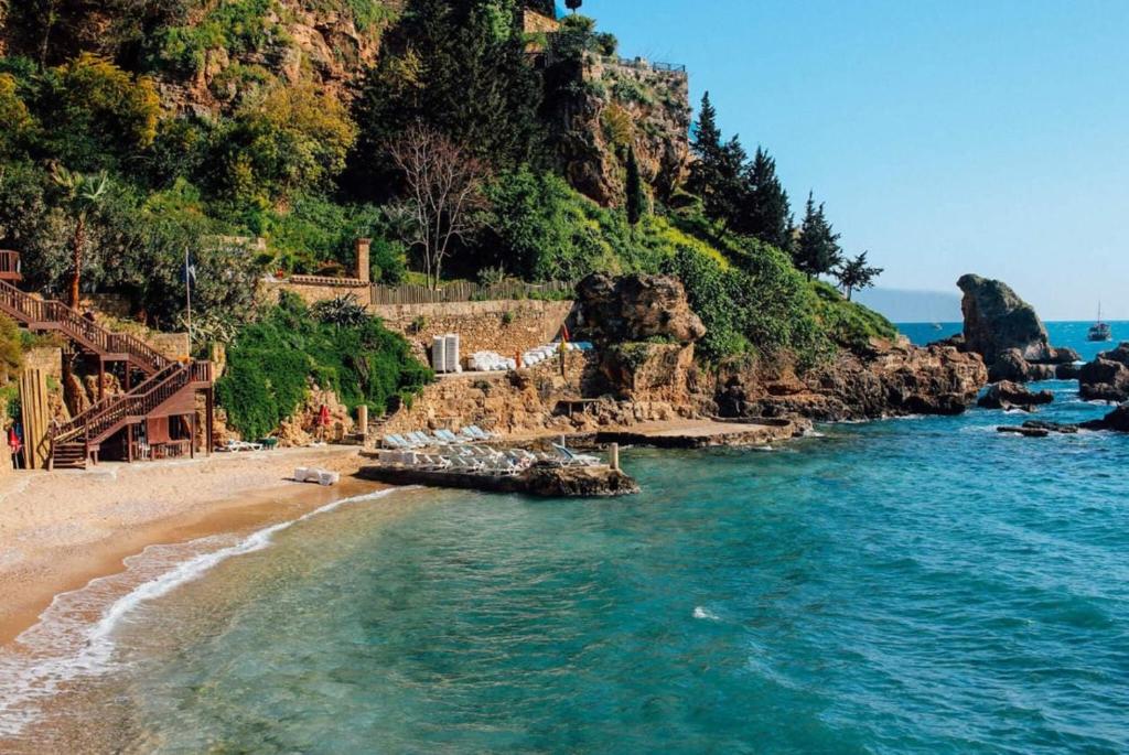 ATICI HOTEL في أنطاليا: شاطئ به مجموعة من الكراسي على الشاطئ