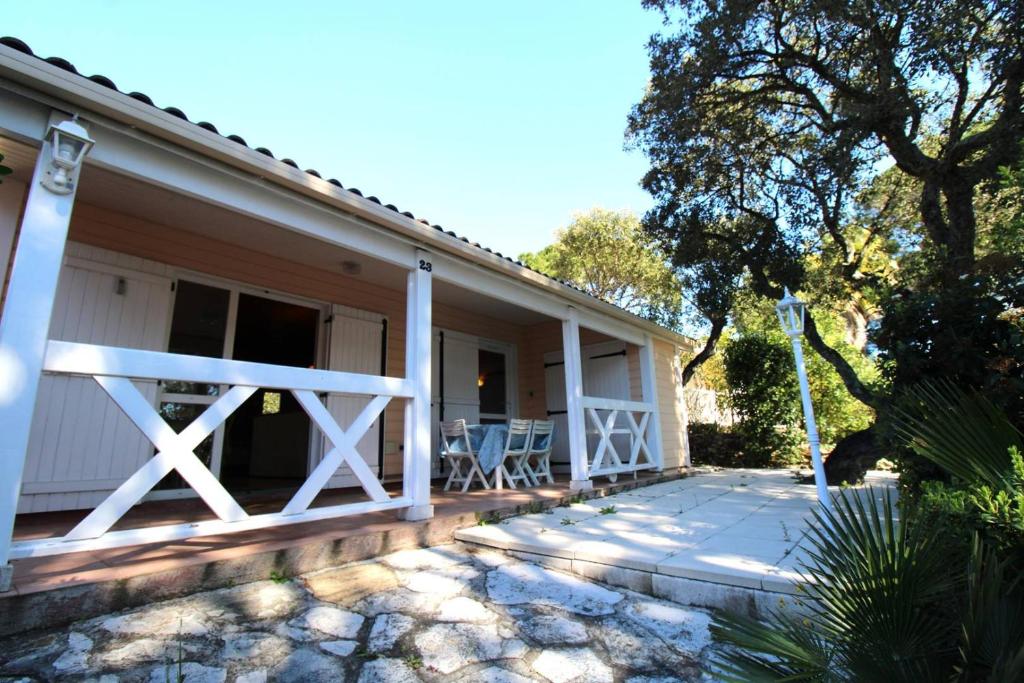 ein Haus mit einer Veranda mit einem weißen Zaun in der Unterkunft GASPRO23 - Golfe de St-Tropez - Maison californienne pour 6 personnes dans domaine privé in Gassin