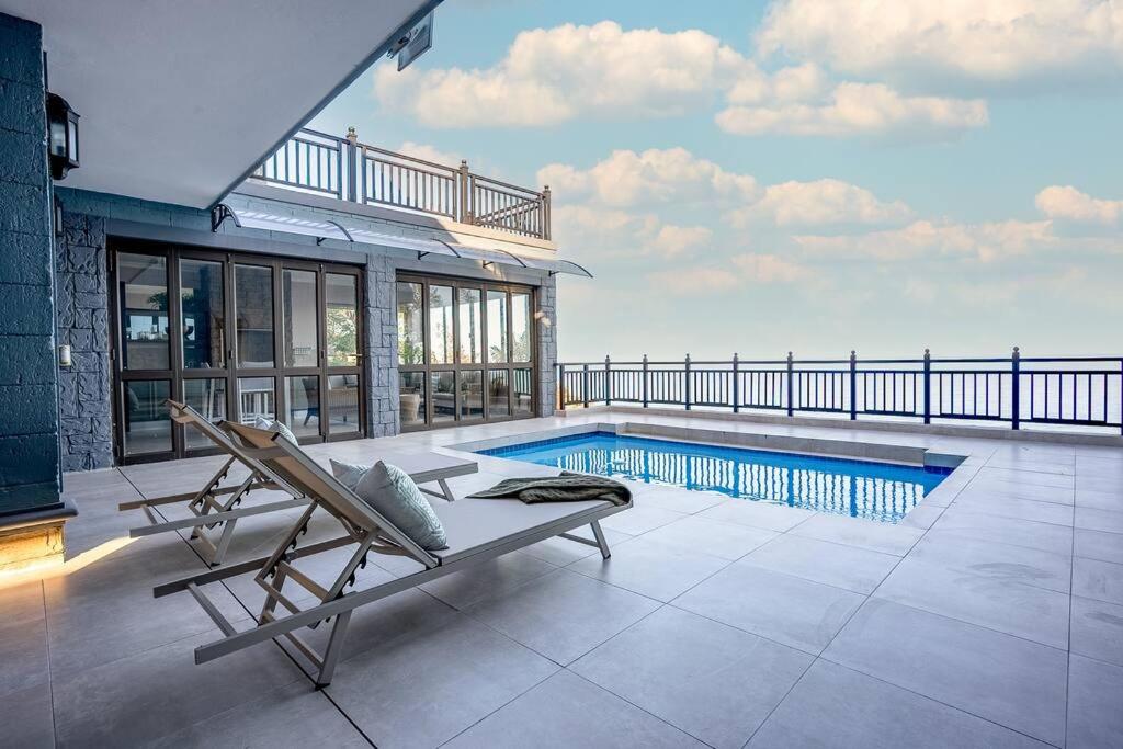 une villa avec une piscine et un banc sur une terrasse dans l'établissement Entire Home in Sheffield Beach, à Sheffield Beach