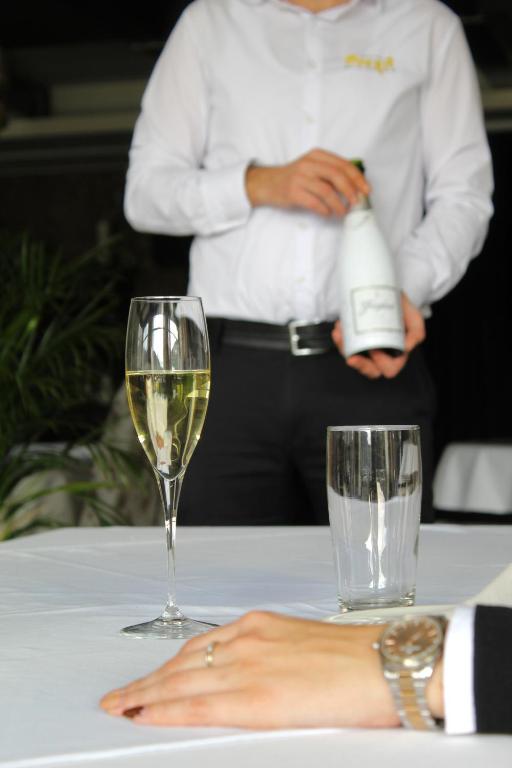a woman sitting at a table with a glass of wine at Hotel Opera Jaz in Budva