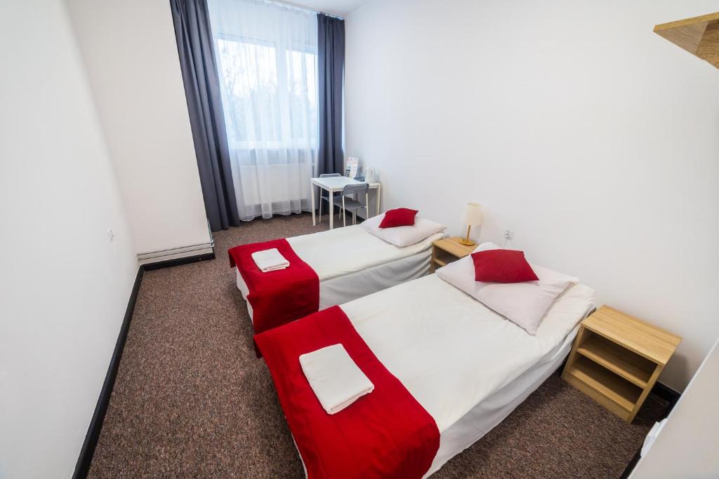 ein Hotelzimmer mit 2 Betten und einem Tisch in der Unterkunft Pokoje gościnne OSiR in Zamość