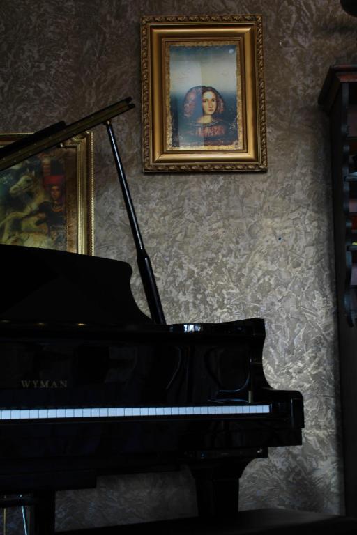 a piano in a room with a picture on the wall at Hotel Opera Jaz in Budva
