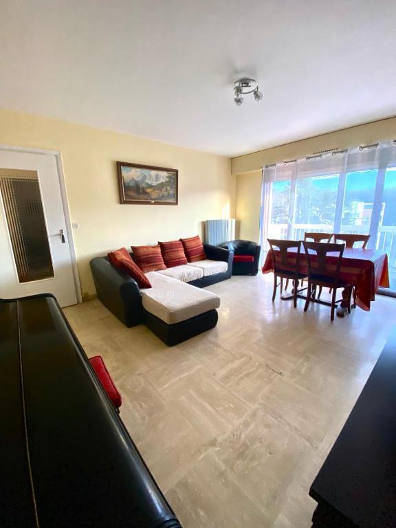 un salon avec un canapé et une table dans l'établissement Appartement proche Gare, à Saint-Julien-en-Genevois